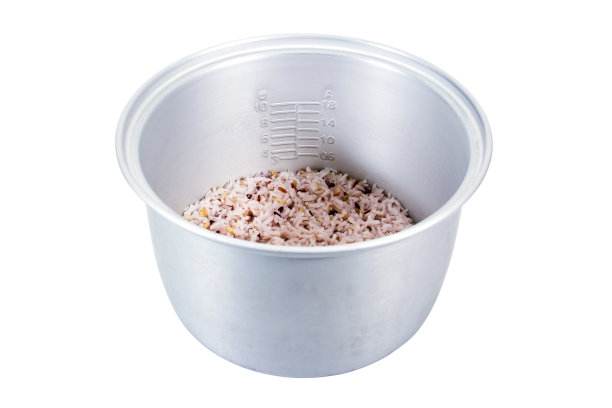 电饭锅内部，米饭和鳞片被孤立在白色的背景上图片下载