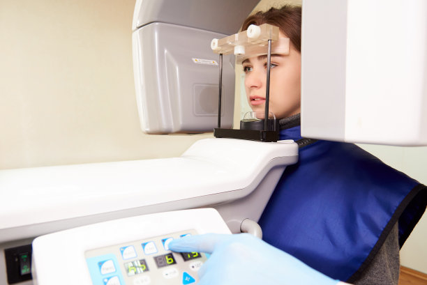 病人站在x光机里。全景摄影。牙科的计算机断层摄影术。图片下载