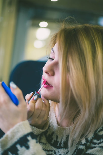 可爱的年轻女孩的特写肖像涂上红色的口红图片下载