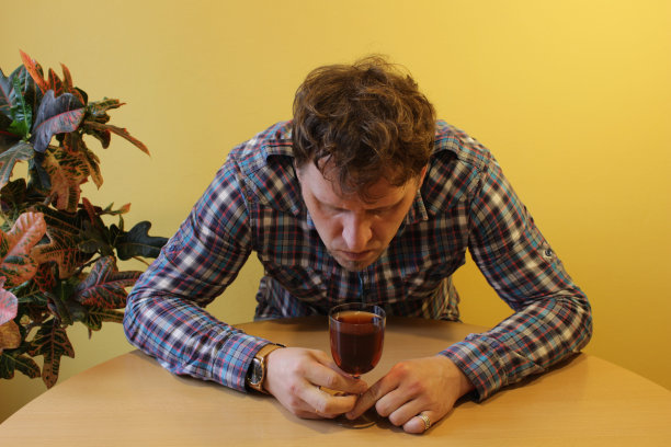 一个拿着一杯酒的男人。酗酒。图片下载