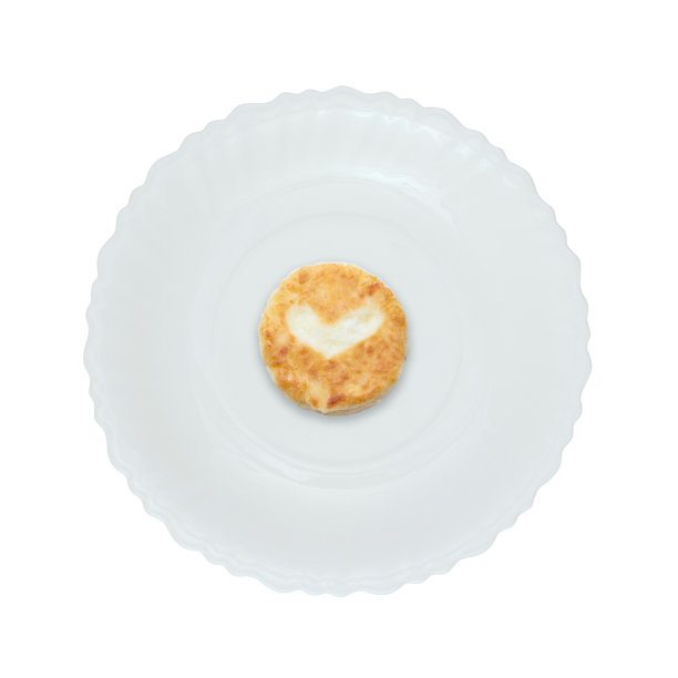 白色盘子上的心形芝士蛋糕。孤立。图片下载