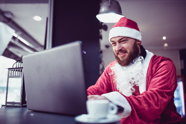 年轻的圣诞老人在电脑上查看本地地图图片下载