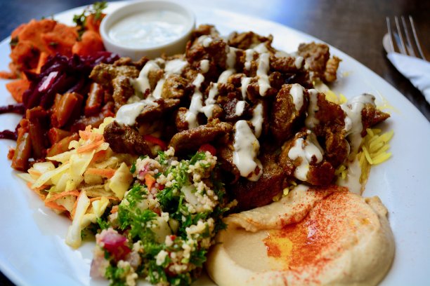 羊肉串的特写照片，配上传统香米、腐殖质、新鲜沙拉和酸奶薄荷酱图片下载