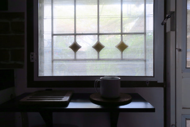 咖啡杯侧影放在窗边图片下载