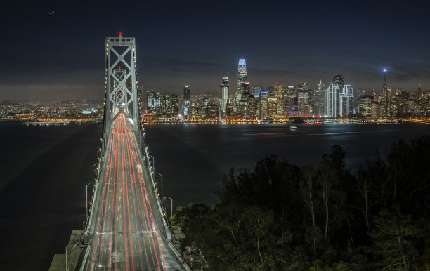 旧金山的天际线和海湾大桥在晚上从Yerba Buena岛，美国加利福尼亚州图片下载
