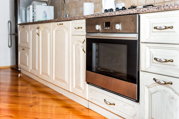 现代的木制棕色厨房特色橱柜与花岗岩台面和瓷砖后溅与肮脏的烤箱特写图片下载