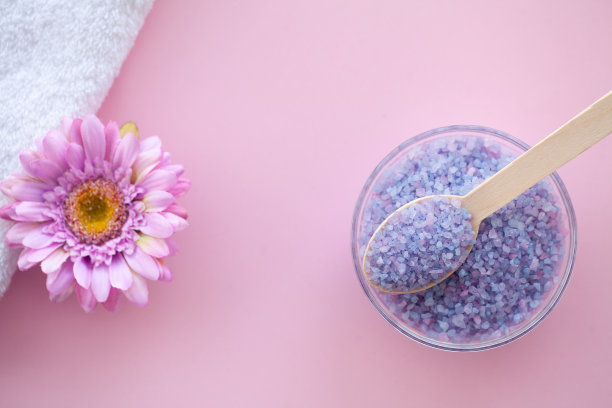 水疗中心。卷白色身体毛巾在粉红色的背景。毛巾的概念。酒店和按摩院照片。纯洁和温柔。毛巾织物。图片下载