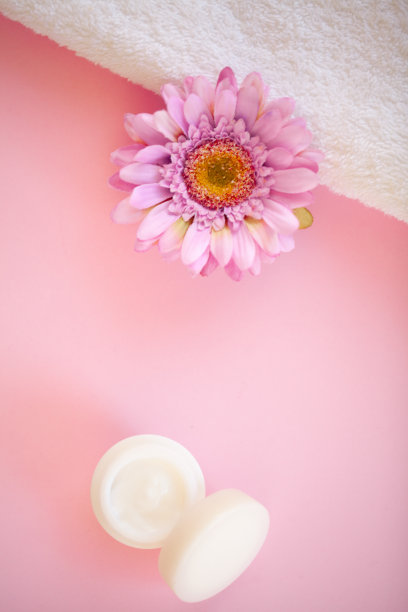 水疗中心。卷白色身体毛巾在粉红色的背景。毛巾的概念。酒店和按摩院照片。纯洁和温柔。毛巾织物。图片下载