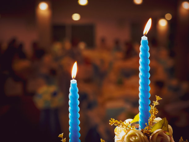 爱情和婚礼活动与情人节的概念从两个婚礼蓝色蜡烛与火装饰大厅与软焦点人的背景图片下载