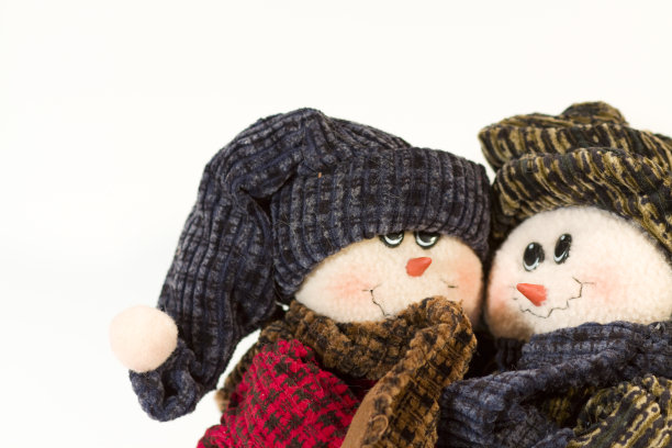 可爱的毛绒雪人夫妇拥抱在一个干净的白色背景图片下载