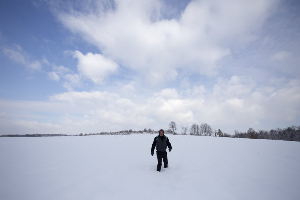 一名成年男子戴着针织帽在雪地上徒步旅行图片下载