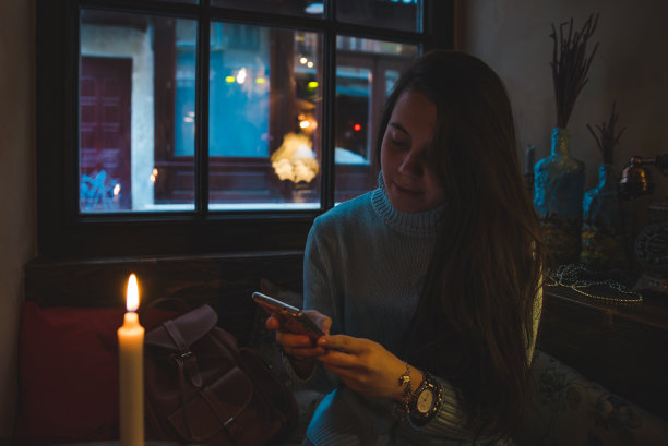 女人坐在咖啡馆喝茶，通过智能手机上网图片下载