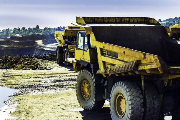 后面有一辆黄色卡车，前面有一辆，后面是矿井图片下载