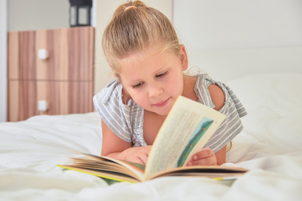 女孩躺在床上看书图片下载