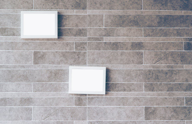 室内海报模型，白色相框附在棕色的墙上。图片下载