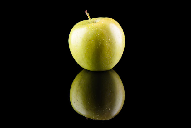 绿苹果和水滴在黑色背景反射图片下载