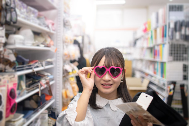 年轻女子在试一副有趣的粉色太阳镜图片下载