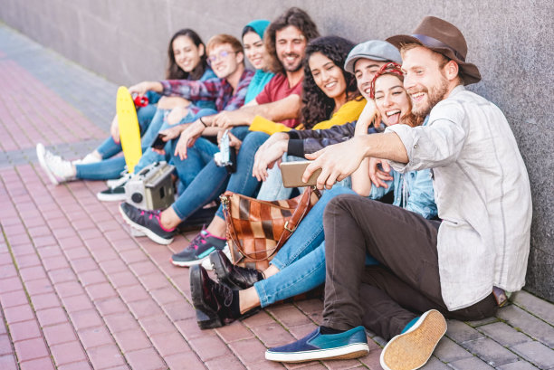 一群年轻人自拍分享故事社交网络应用-千禧一代的朋友与新趋势技术的乐趣-青年，科技，和友谊的概念-专注于智能手机手图片下载