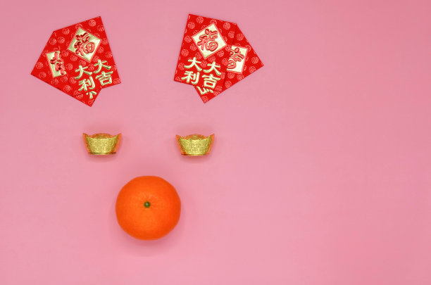 春节背景:猪脸用压岁钱包做耳朵(寓意财运、利润和兴旺)，金元宝做眼睛(寓意财富)，橘子做鼻子。图片下载