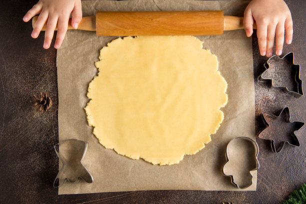 孩子们正在做圣诞饼干，擀出面团，家庭传统，美味甜蜜的节日食品图片下载