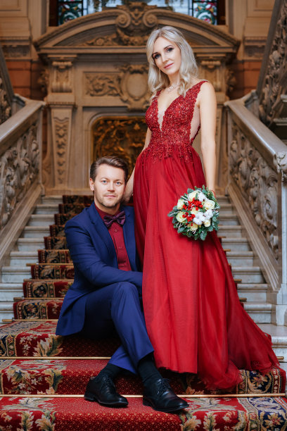 一个穿着红裙子的漂亮女人和一个男人站在一起，新娘和新郎，幸福的新婚夫妇。图片下载