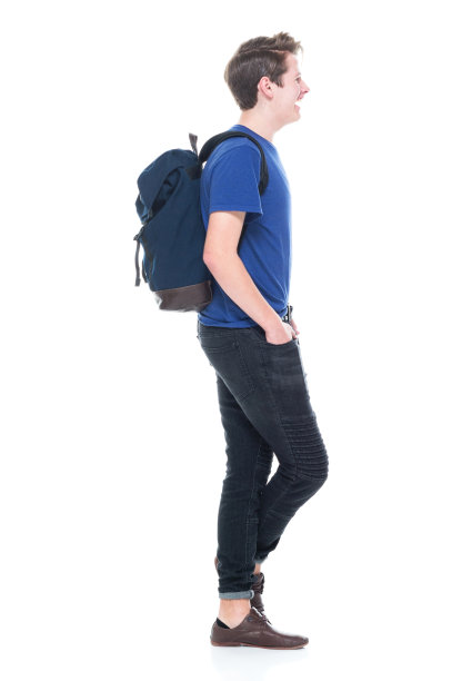 年轻的高中男生背着背包，双手插在口袋里图片下载