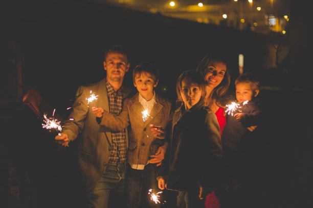 腰上的肖像，幸福的家庭一起庆祝新年和照明烟花户外图片下载