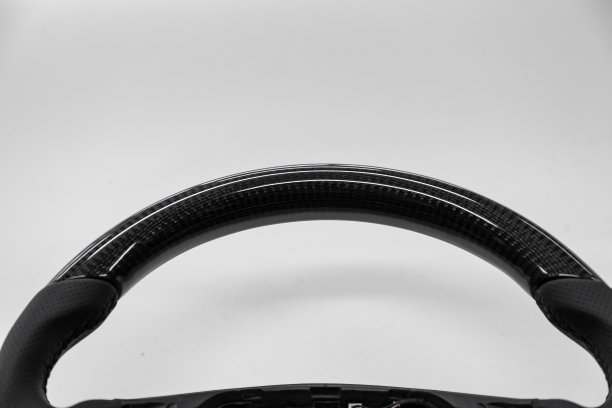 汽车内部的细节元素是一个不同寻常的碳方向盘缝合紫色线从真正的黑色皮革在一个汽车修理车间的特写。图片下载