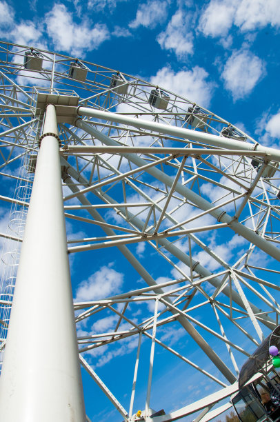 公园里的早春。摩天轮。旋转木马游乐园或露天游乐场的游乐设施，由一个巨大的垂直旋转的轮子组成，外缘悬挂着客车图片下载