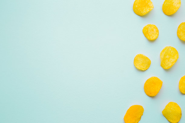 淡蓝色背景上的黄色土豆片。前视图。文本的空位置。图片下载