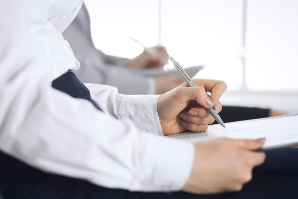 商务人士在办公室参加会议或培训，特写。女人坐在椅子上做笔记，就像排队或开会时一样。图片下载