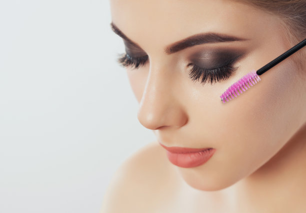 长睫毛的美女在美容院。睫毛扩展过程。图片下载