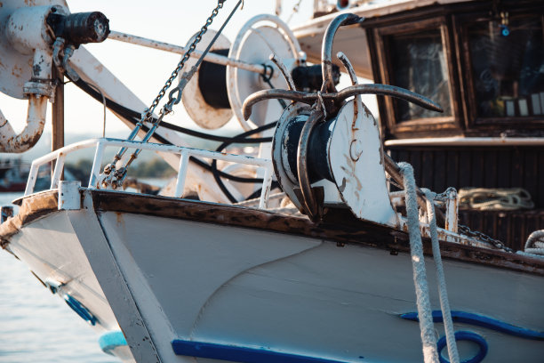 渔船船头与生锈的锚和航海设备系泊在希腊港在日落图片下载