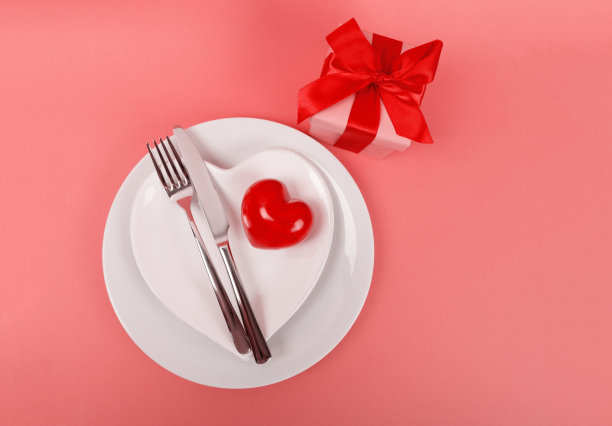 白色盘子上的红心和厨房餐具放在活珊瑚桌上图片下载