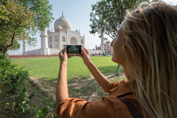 年轻女子用手机拍摄泰姬陵图片下载