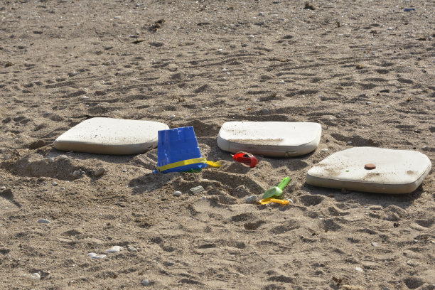 游戏结束了——塑料玩具和枕头被遗忘在海滩上图片下载