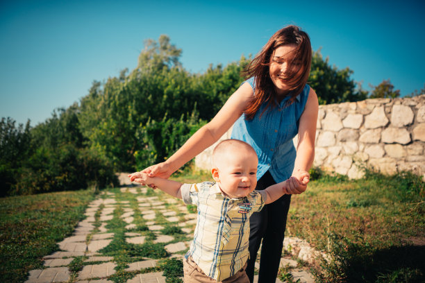 自然背景下，快乐的母亲和幼儿儿子图片下载