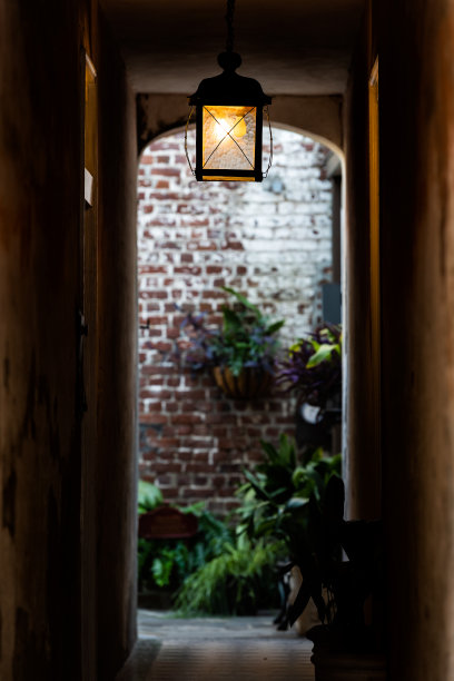 古色古香的古色古香的砖石建筑和狭窄阴暗的小巷，垂直视野中可见灯光通明的隧道通道图片下载