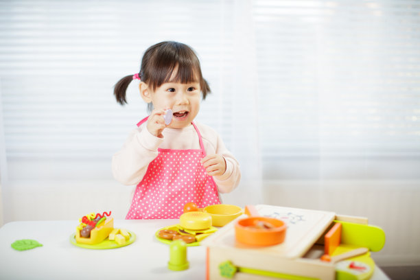 蹒跚学步的小女孩假装玩食物准备图片下载