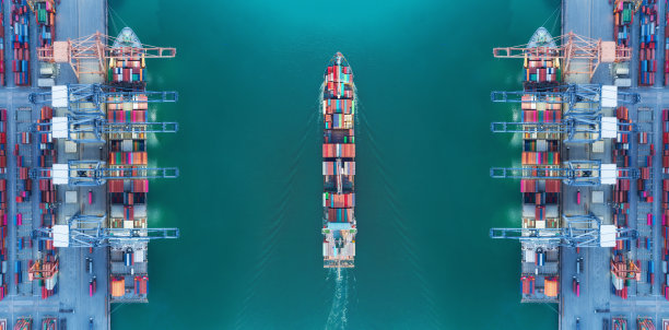 鸟瞰图全景集装箱船移动通过海港仓库和起重机船工作交付集装箱装运，物流进口进口或运输概念。图片下载