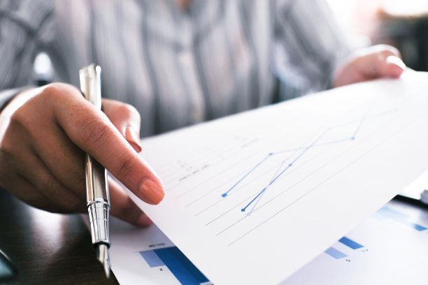 商业女性分析投资图表和按计算器按钮的文件。会计的概念。图片下载