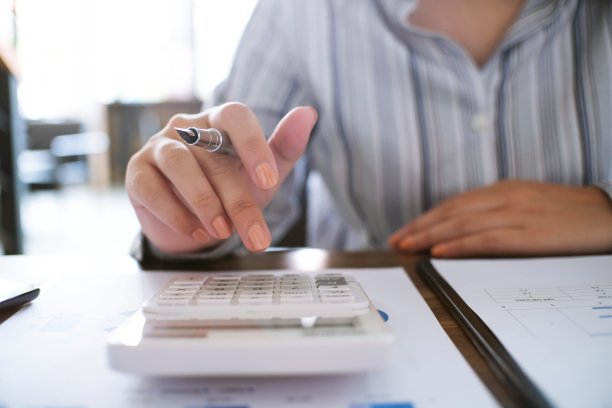 商业女性分析投资图表和按计算器按钮的文件。会计的概念。图片下载