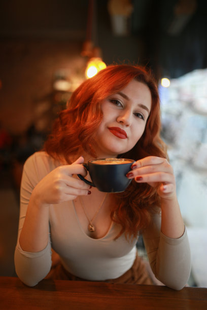 红发女孩在咖啡厅喝咖啡图片下载