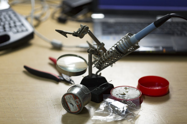 焊接工具与图形木桌，模糊标签打印机和笔记本电脑。图片下载