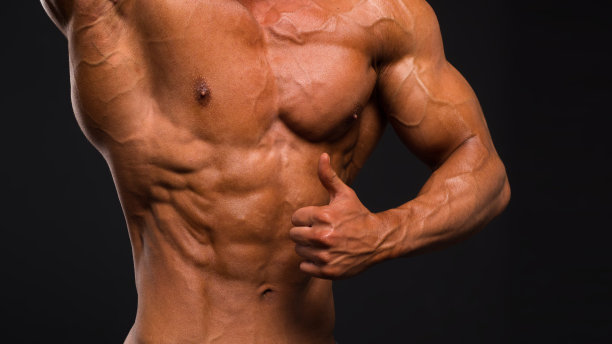 低调形象的肌肉男性在黑暗的背景。图片下载