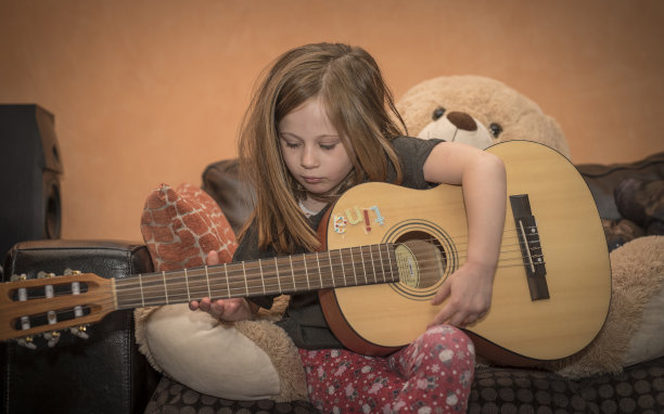 年轻女孩在家弹吉他图片下载
