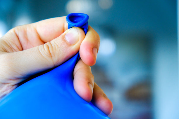 手系气球蓝色背景近距离投掷派对准备服务图片下载