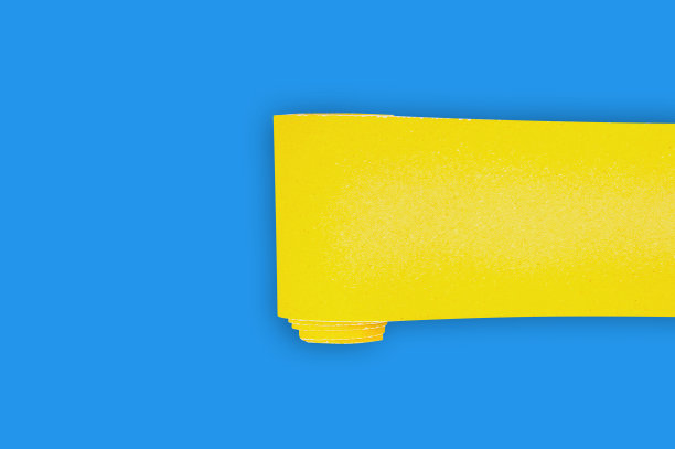 一卷新的黄色砂纸，用于车间蓝色桌子上的格子木或金属物品。为你的文本复制空间。前视图。建筑或修理概念图片下载