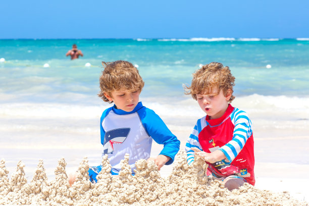 两个小男孩正在岛上的热带海滩上玩沙堡。健康的孩子们在一起度假。双胞胎，快乐的兄弟笑着笑着图片下载
