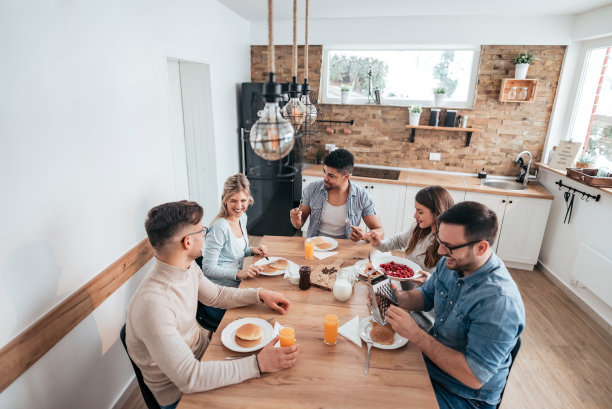 朋友们吃着自制的煎饼，玩得很开心的高角度图片。图片下载